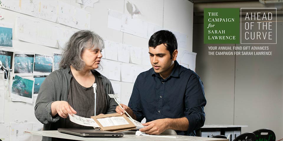 Two people discussing a project and looking at paper prototypes