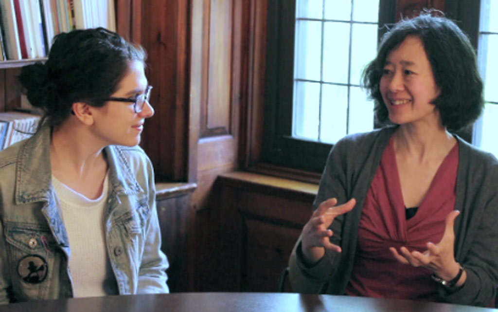 Photo of student and faculty member talking at a table