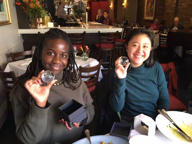 Portrait of two students holding crystal globes