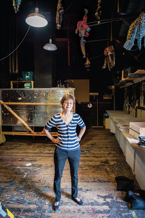 Portrait of Nancie Cooper standing in a theatre workshop