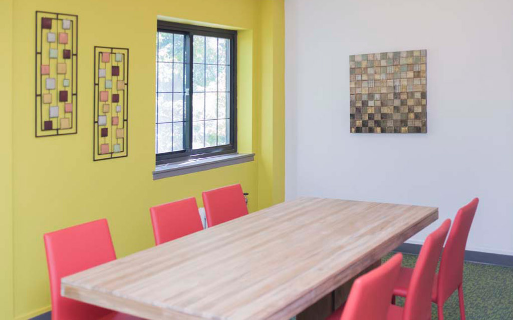 Interior photo of table, chairs, artwork and new paint