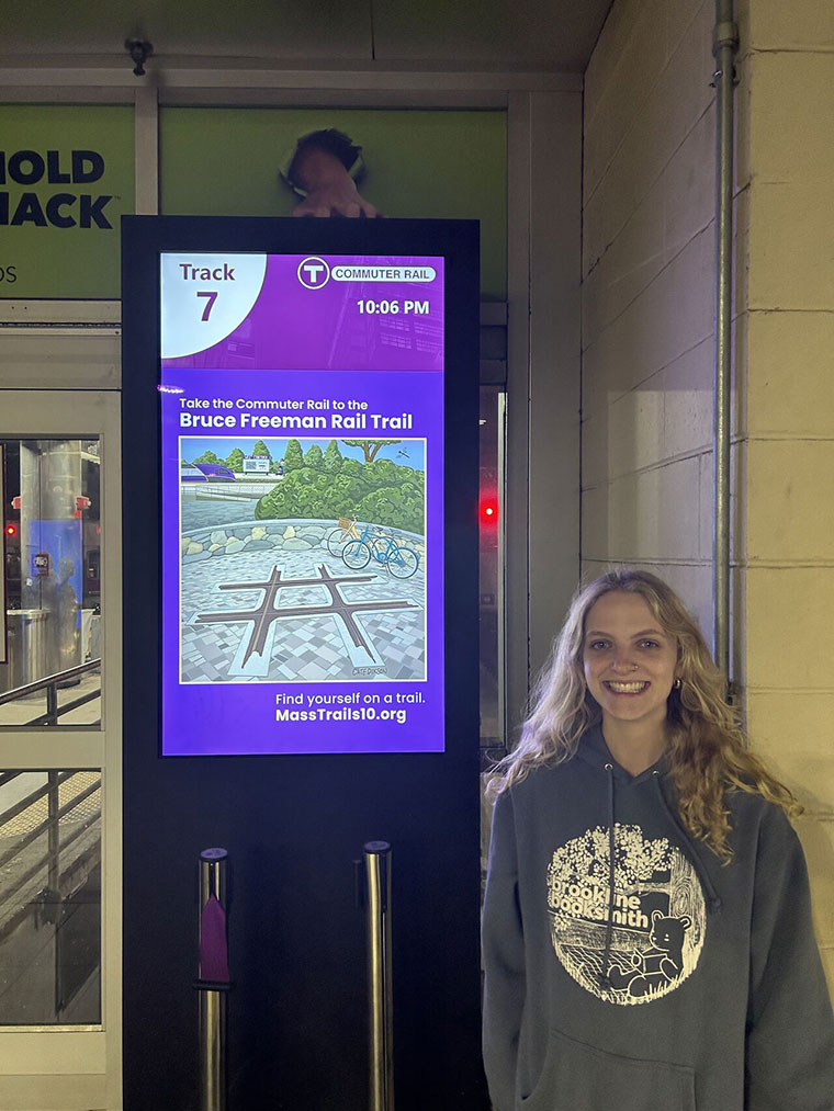 Catherine Dixson posing in front of her illustration