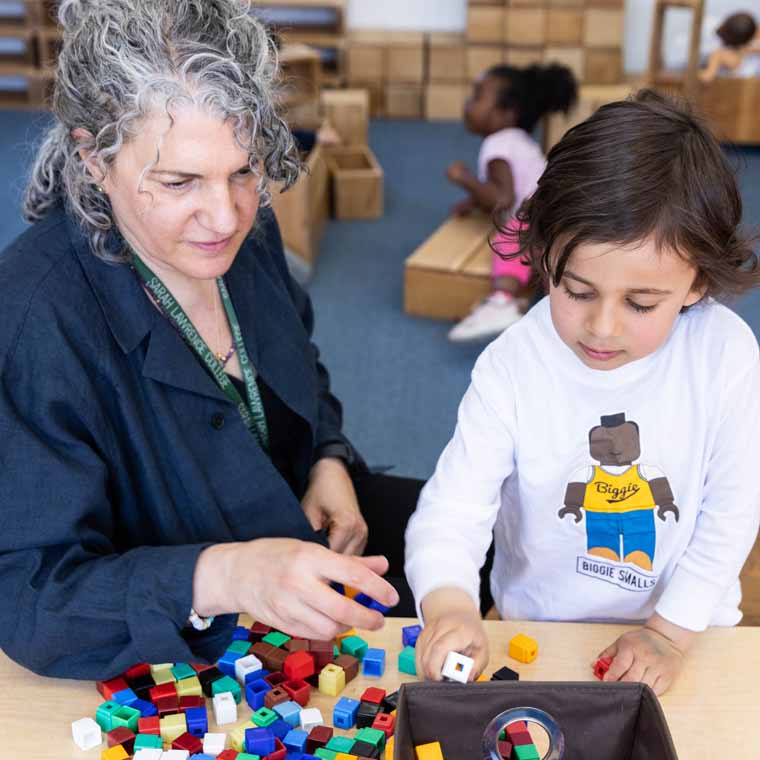 Preschool teacher and student working with materials