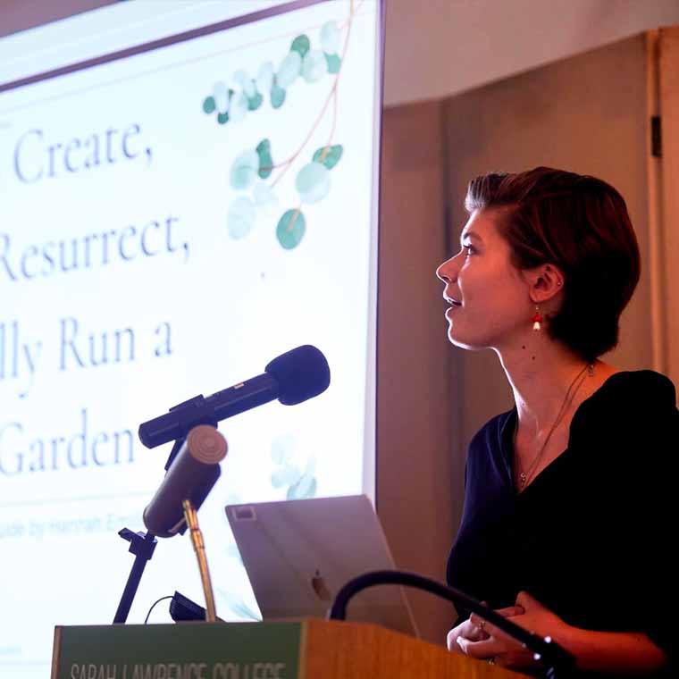 speaker presenting with slide projection in the background