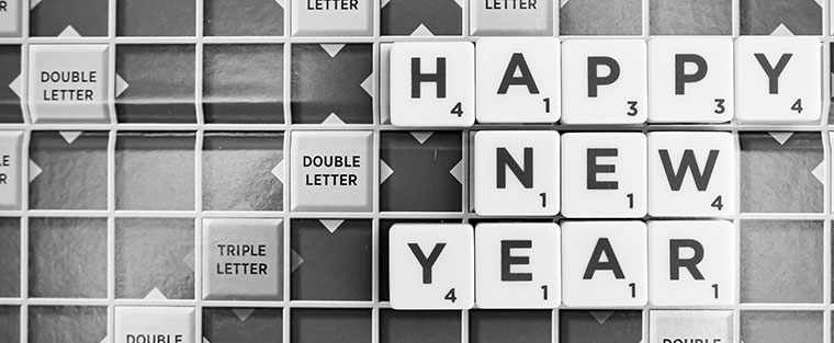 Scrabble game board with words “Happy New Year” spelled out in game pieces