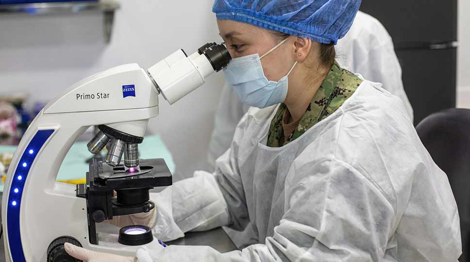 Person looking through microscope