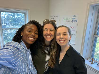 Three people smiling into the camera from a selfie view