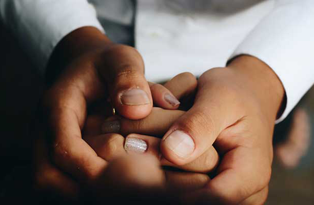 two pairs of hands holding each other