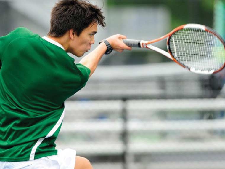 Close-cropped photo of tennis player swinging tennis racket