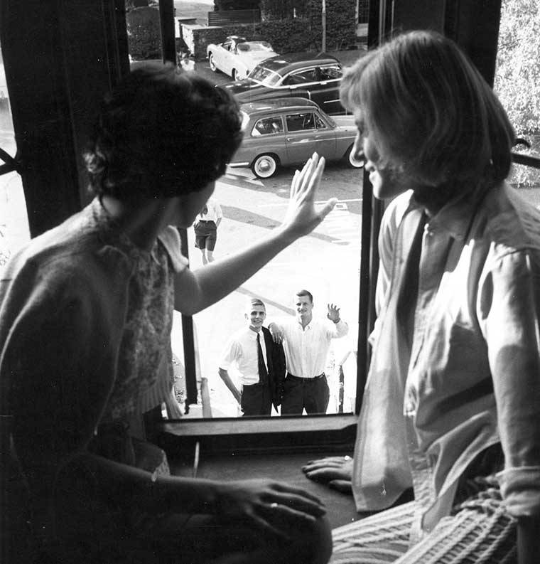 Archival image of girls waving in window