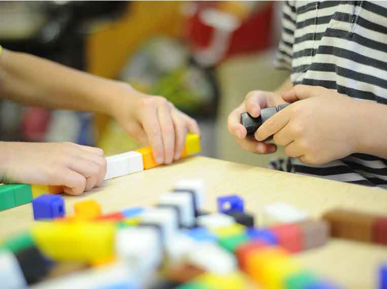 close up of toy blocks and children's hands