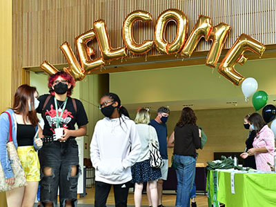 Photo of students in front of balloons that spell out Welcome