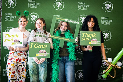Students posing in front of a Sarah Lawrence logo backdrop