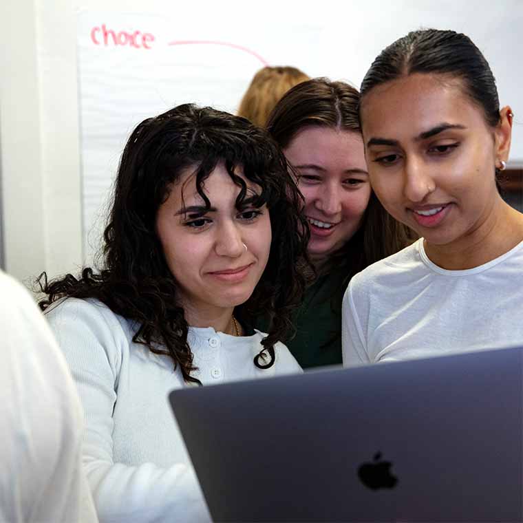 students gathered around laptop
