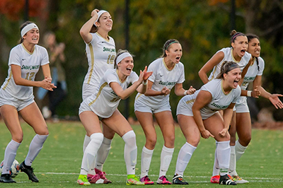 Women's soccer team celebrating on the field