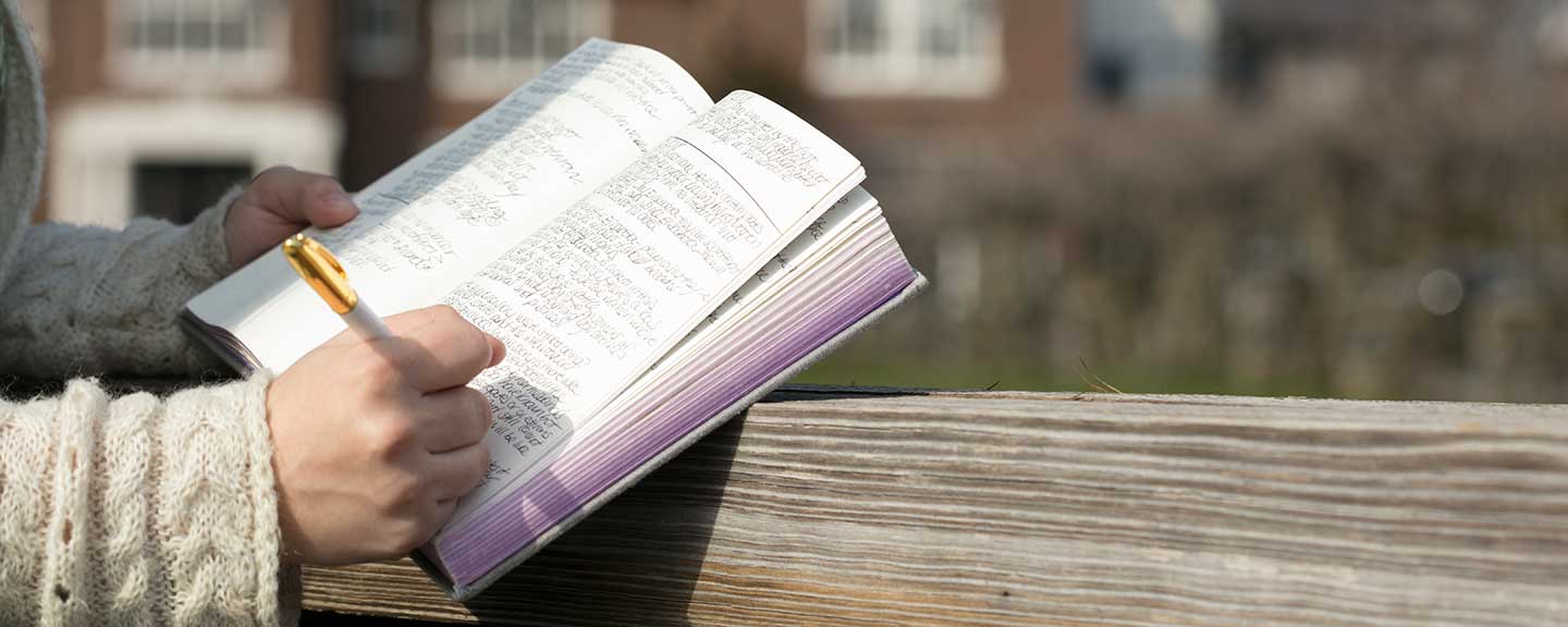 Closeup of person writing in journal