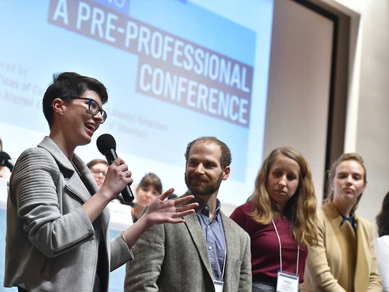 An alum speaks at a microphone at a career panel discussion