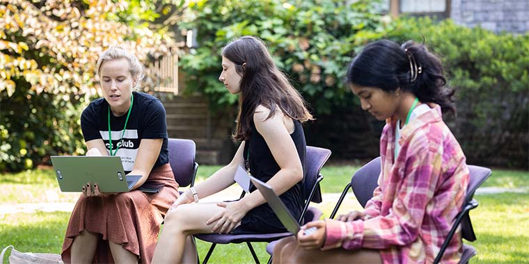 students and instructor outside on chairs in discussion