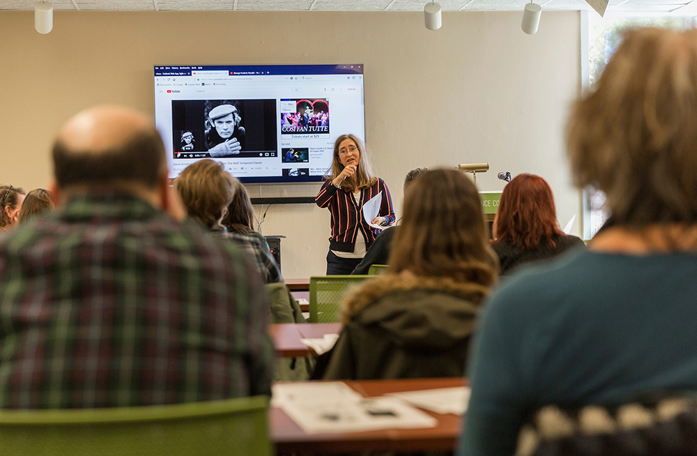 Melissa Frazier teaches in front of a screen as rows of adult students look on