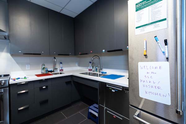View of a new kitchen with a sign on the fridge door: Welcome to the Kosher/Halal Kitchen