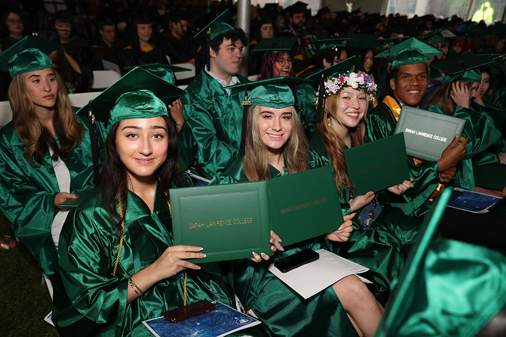 Graduates smiling and holding diplomas