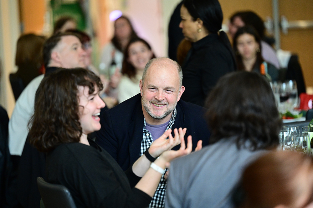 Students and faculty in conversation at a dinner table