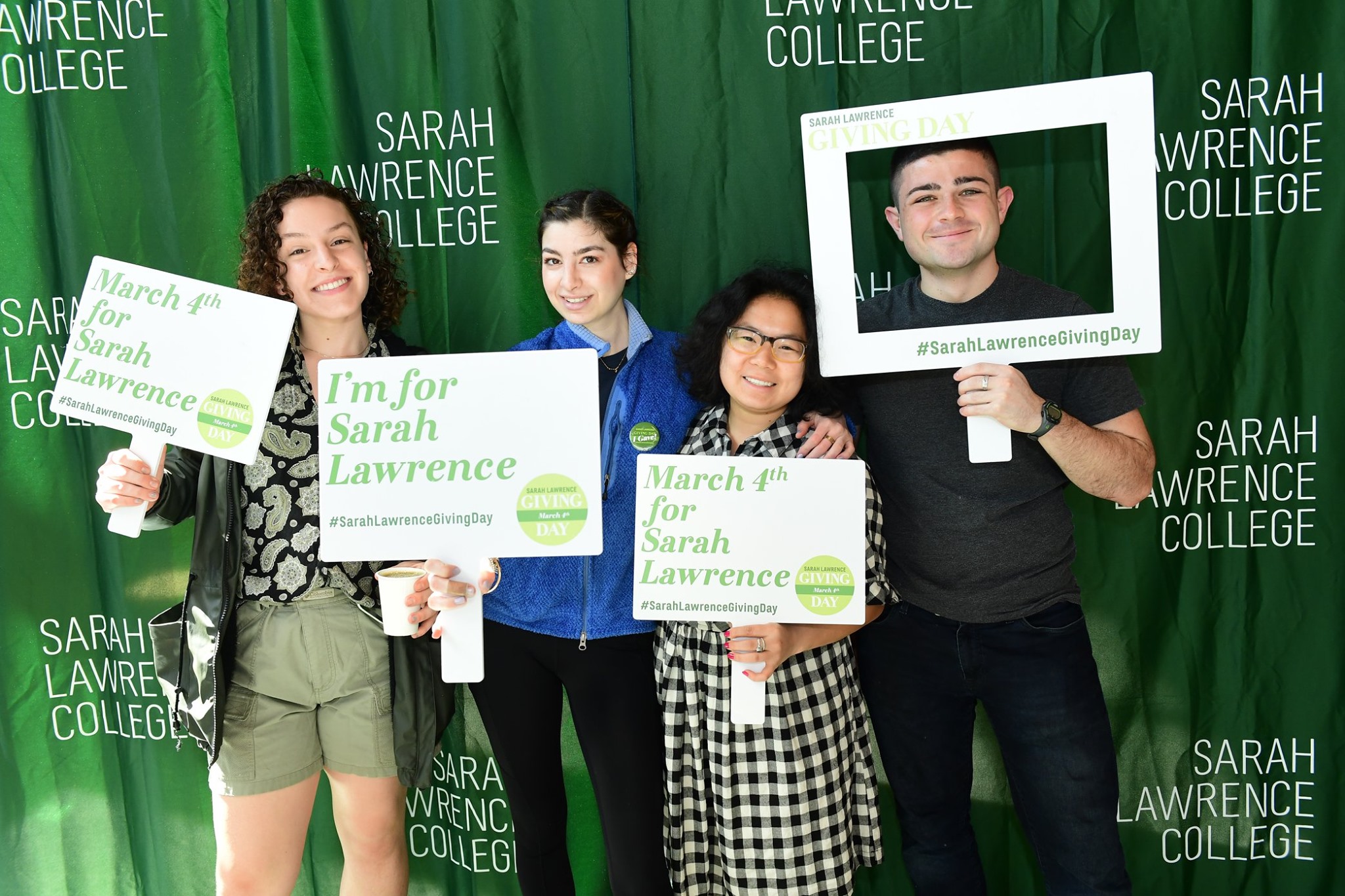 Students at Giving Day holding giving signs