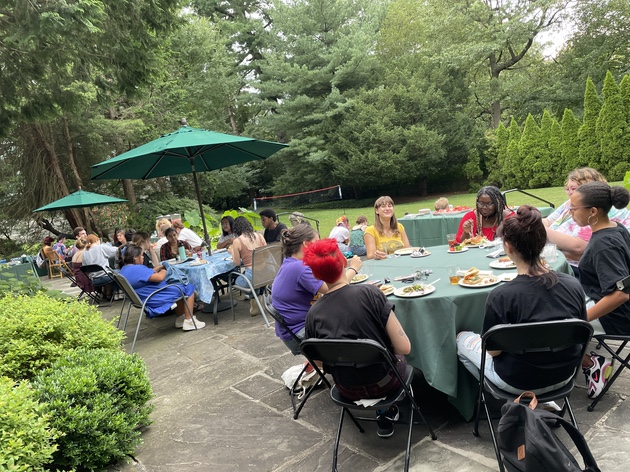 Students gathered around tables at the President's House