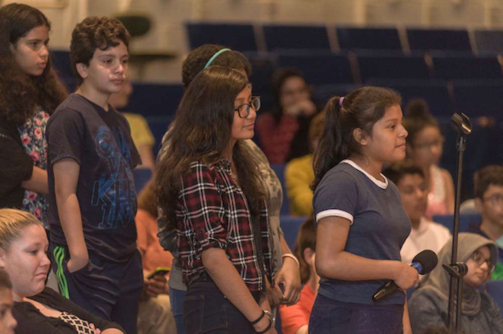 Middle school students standing in audience