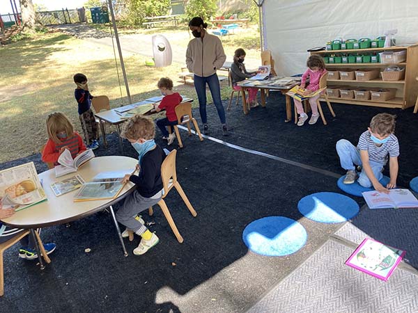 Students learning under a tent