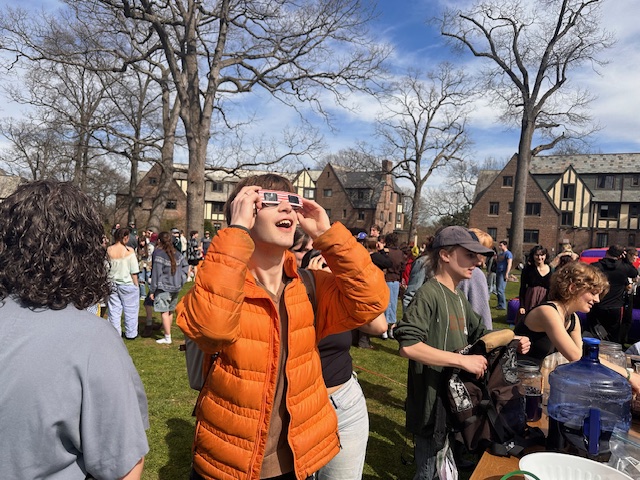 Student looking up at the solar eclipse through eclipse glasses