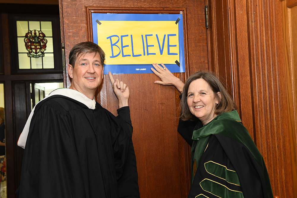 Bill Lawrence and Cristle Collins Judd pointing to a Believe sign