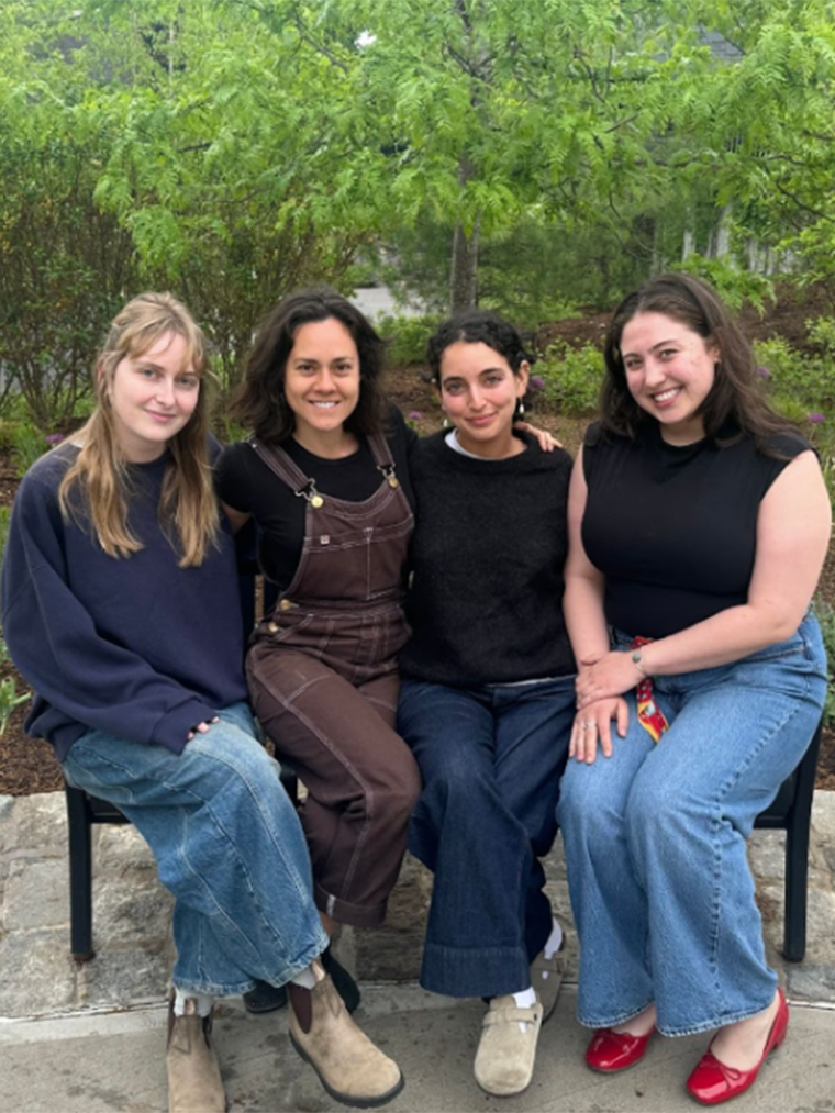 Right to Write student participants sit together on a bench outside