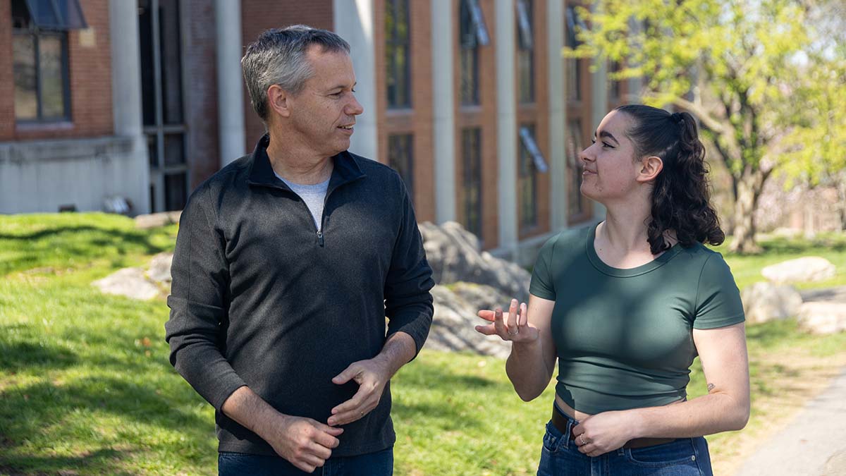 two people walking and talking together outdoors