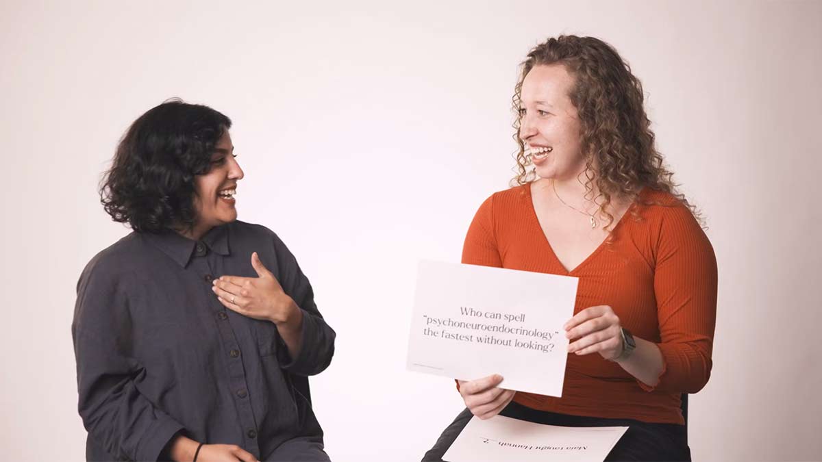 two people sitting and talking indoors. 
