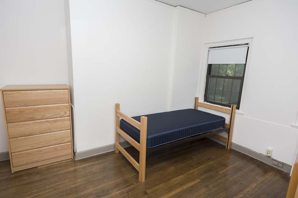 Slonim House dorm room with a bed and bureau