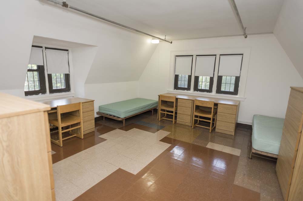 Westlands Hall dorm room with a bed and a few desks with chairs