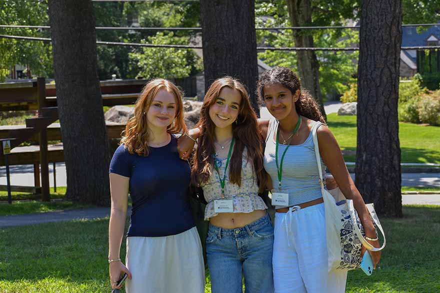 students standing outside close together facing the camera